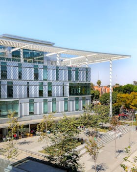 A contemporary campus building with glass features and lush surroundings, capturing a vibrant academic atmosphere.